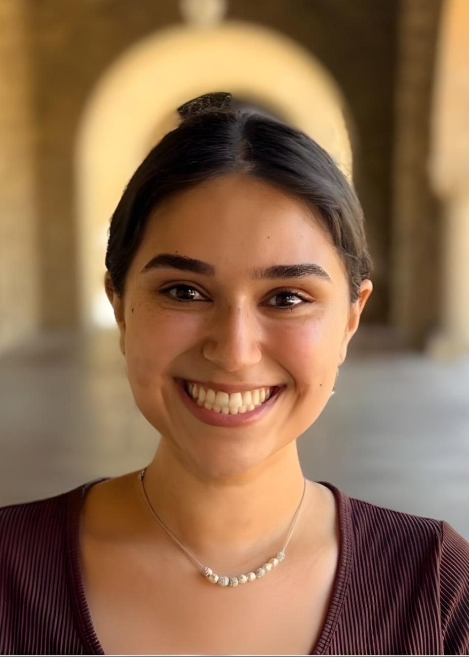 Woman smiling in front of stone arches